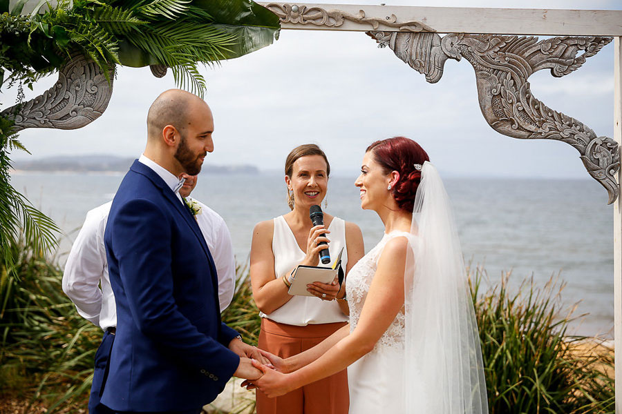 Bride and Groom making vows with celebrant at beach wedding