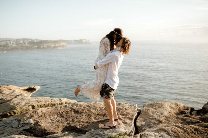 Bride and Groom embrace on clifftop