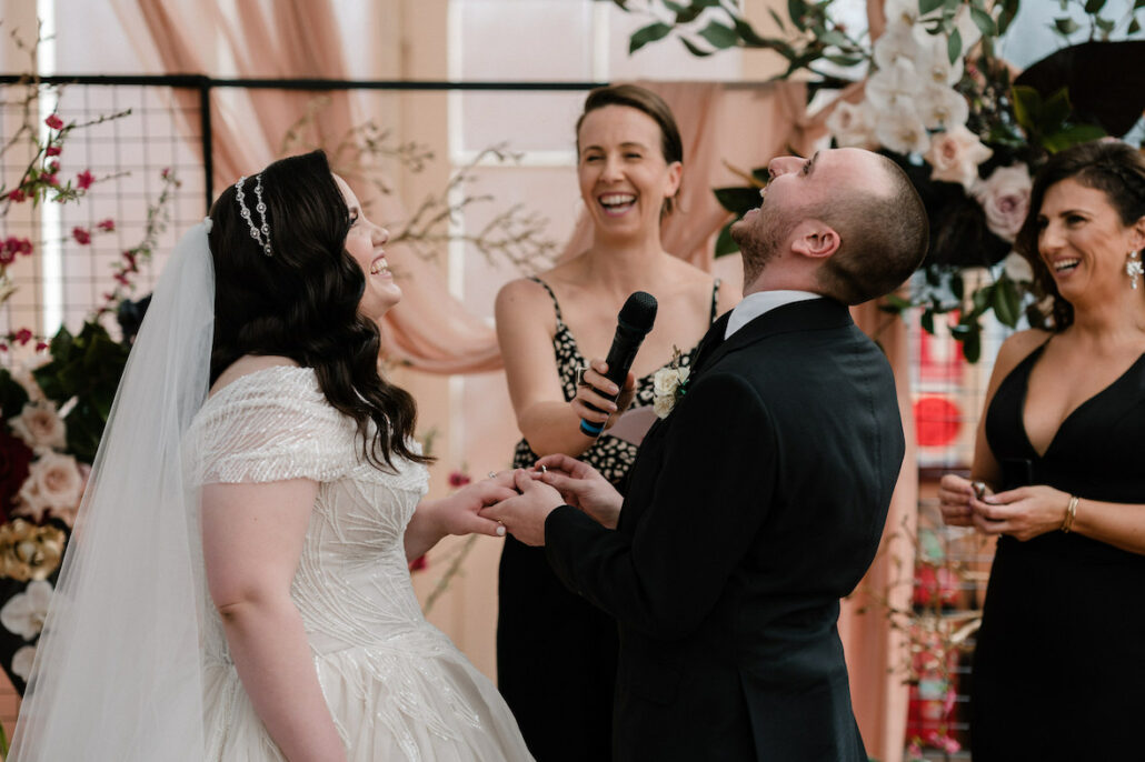 Bride and groom laughing with marriage celebrant