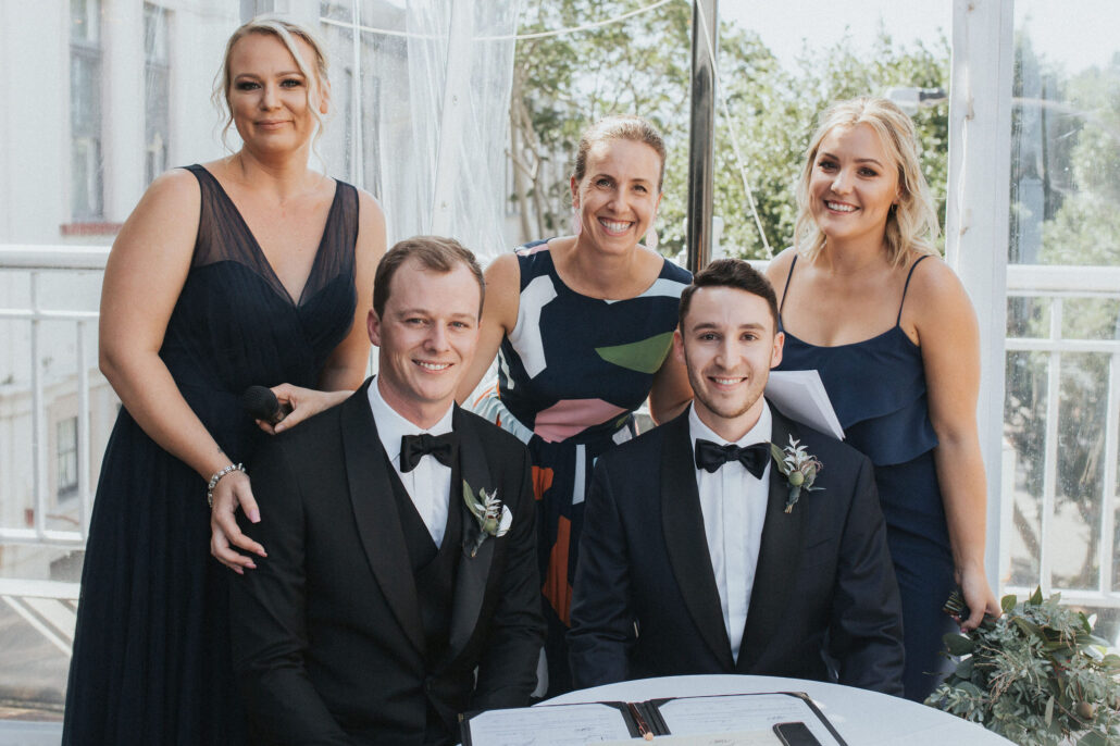 Celebrant with two grooms and their witnesses
