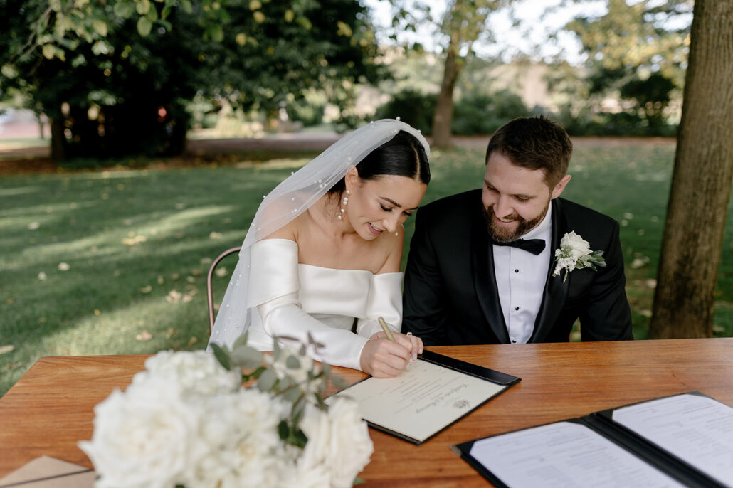 Bride and groom signing marriage paperwork